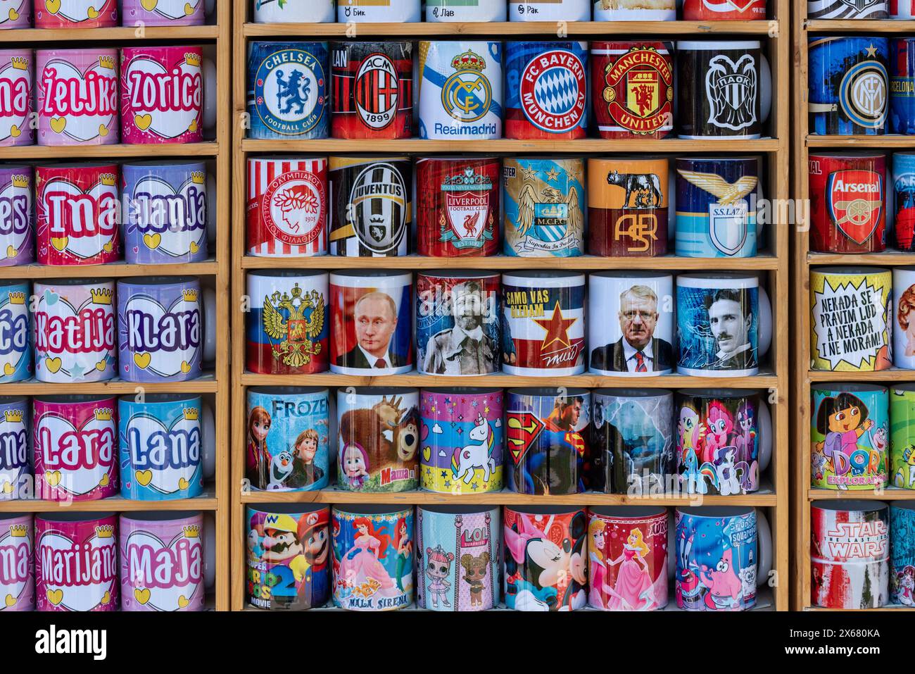 Selection of brightly coloured mugs for sale on the streets of Belgrade. With football teams and famous people like Nikola Tesla and Putin. April 2024 Stock Photo