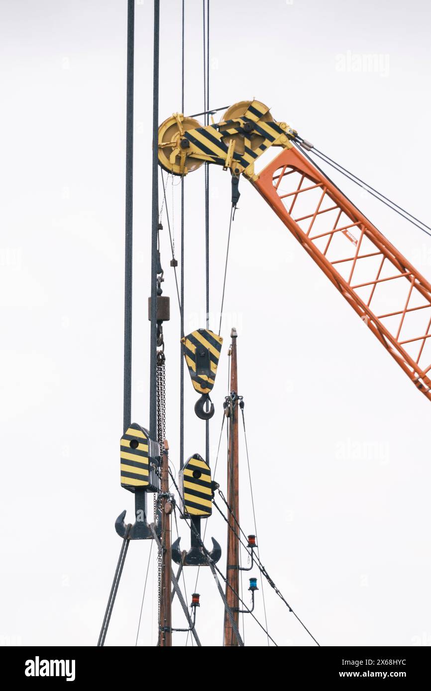 Crane hooks and wooden masts Stock Photo