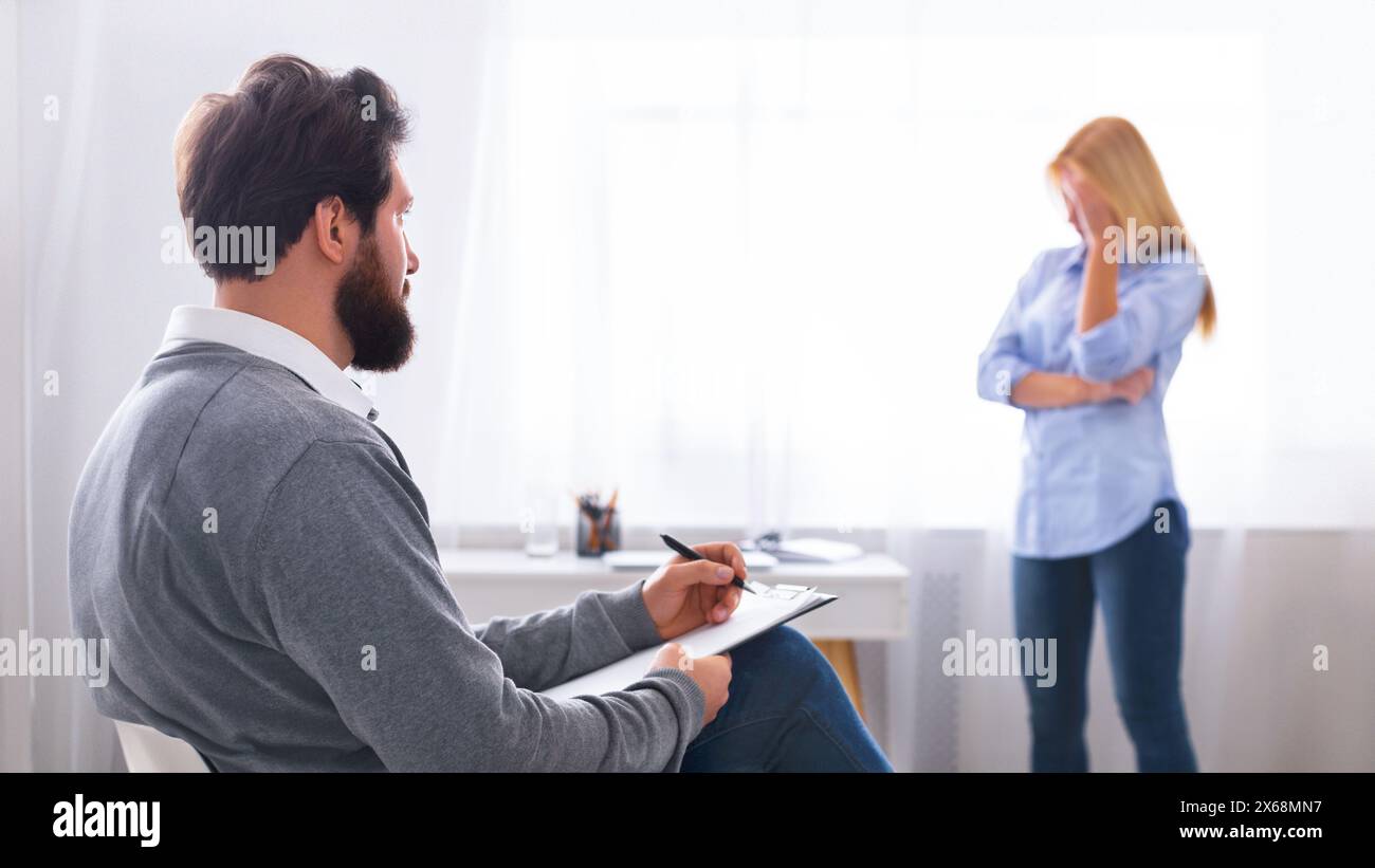 Therapist Taking Notes During a Counseling Session Stock Photo