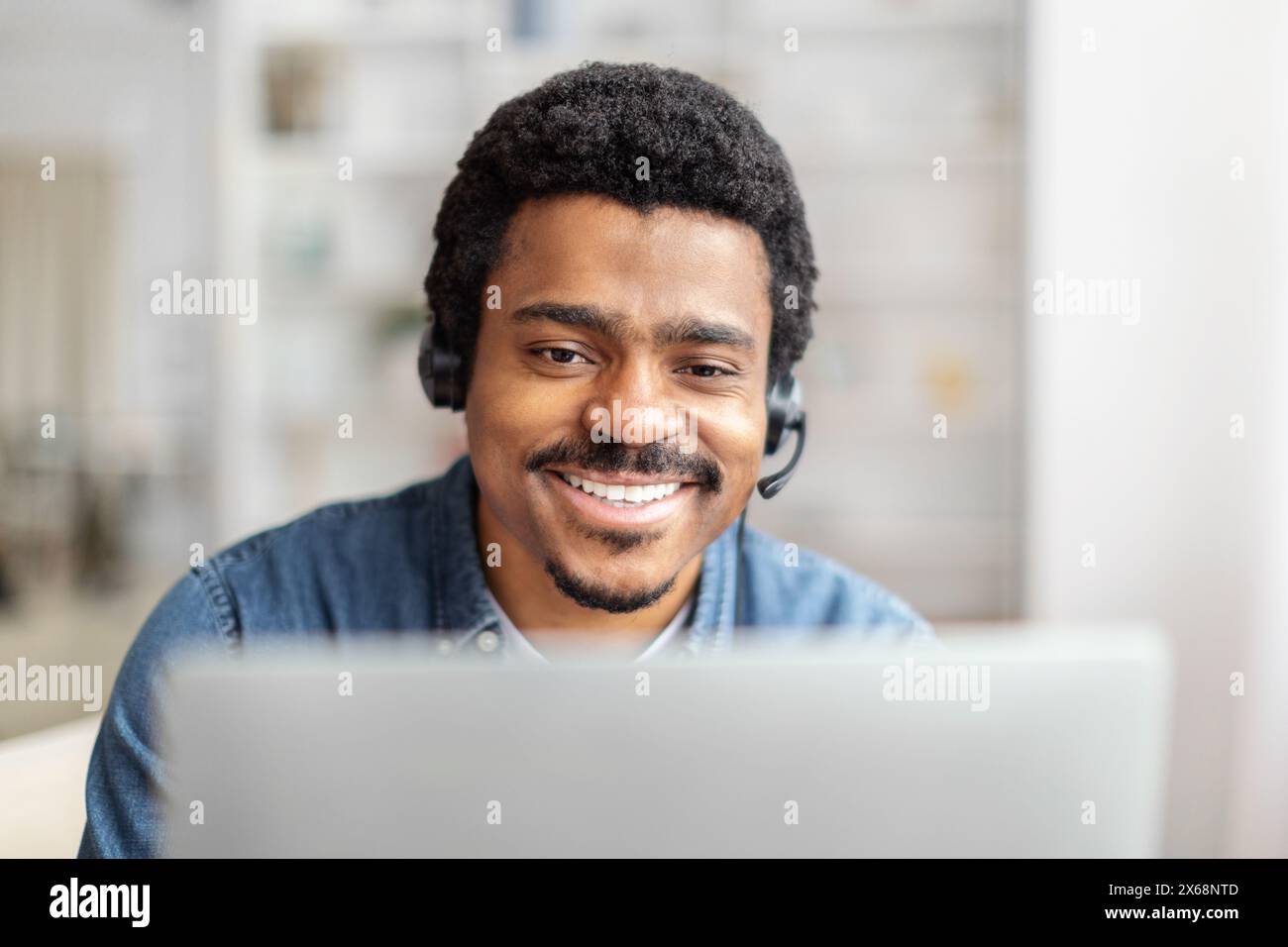 Friendly Customer Support Representative Working on Laptop in Bright Office Stock Photo