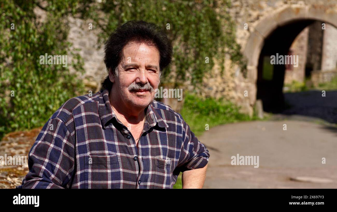Good looking man smiling in front of an old castle. Stock Photo