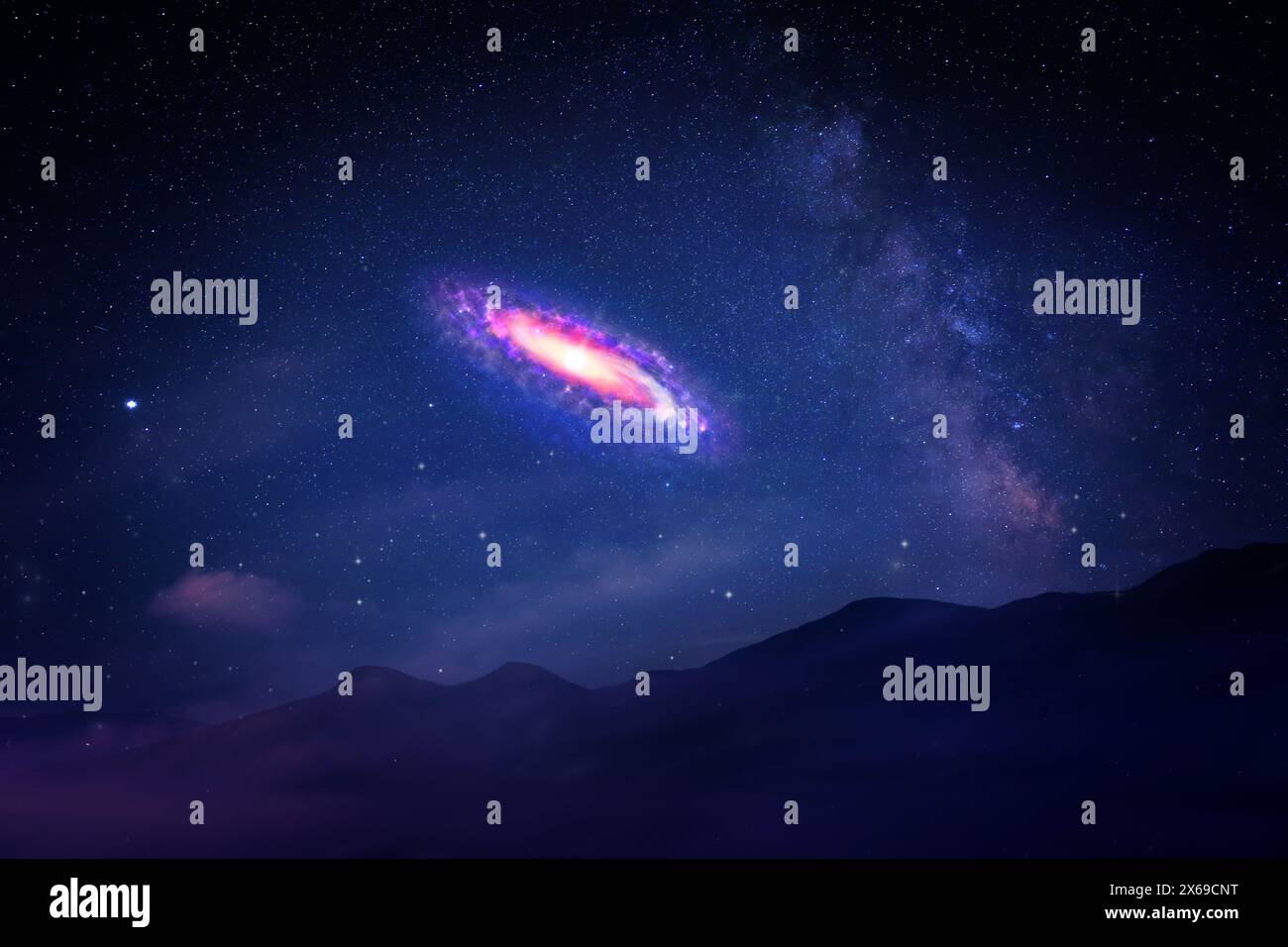 Beautiful spiral galaxy in starry sky over mountains Stock Photo