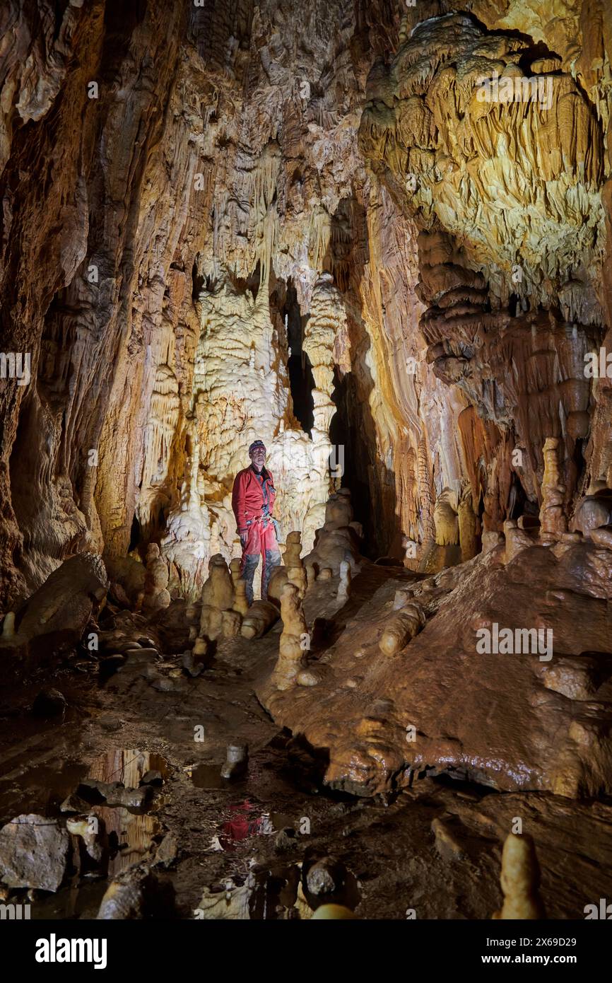Speleologist in a cave, column, stalagmites and stalactites like a cathedral Stock Photo