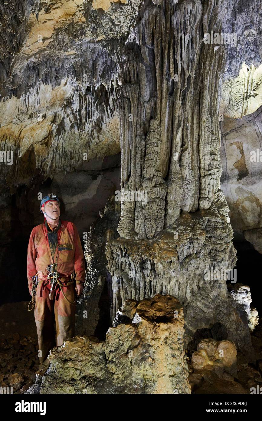 Speleologist in a cave, column, stalagmites and stalactites, stalagnate Stock Photo