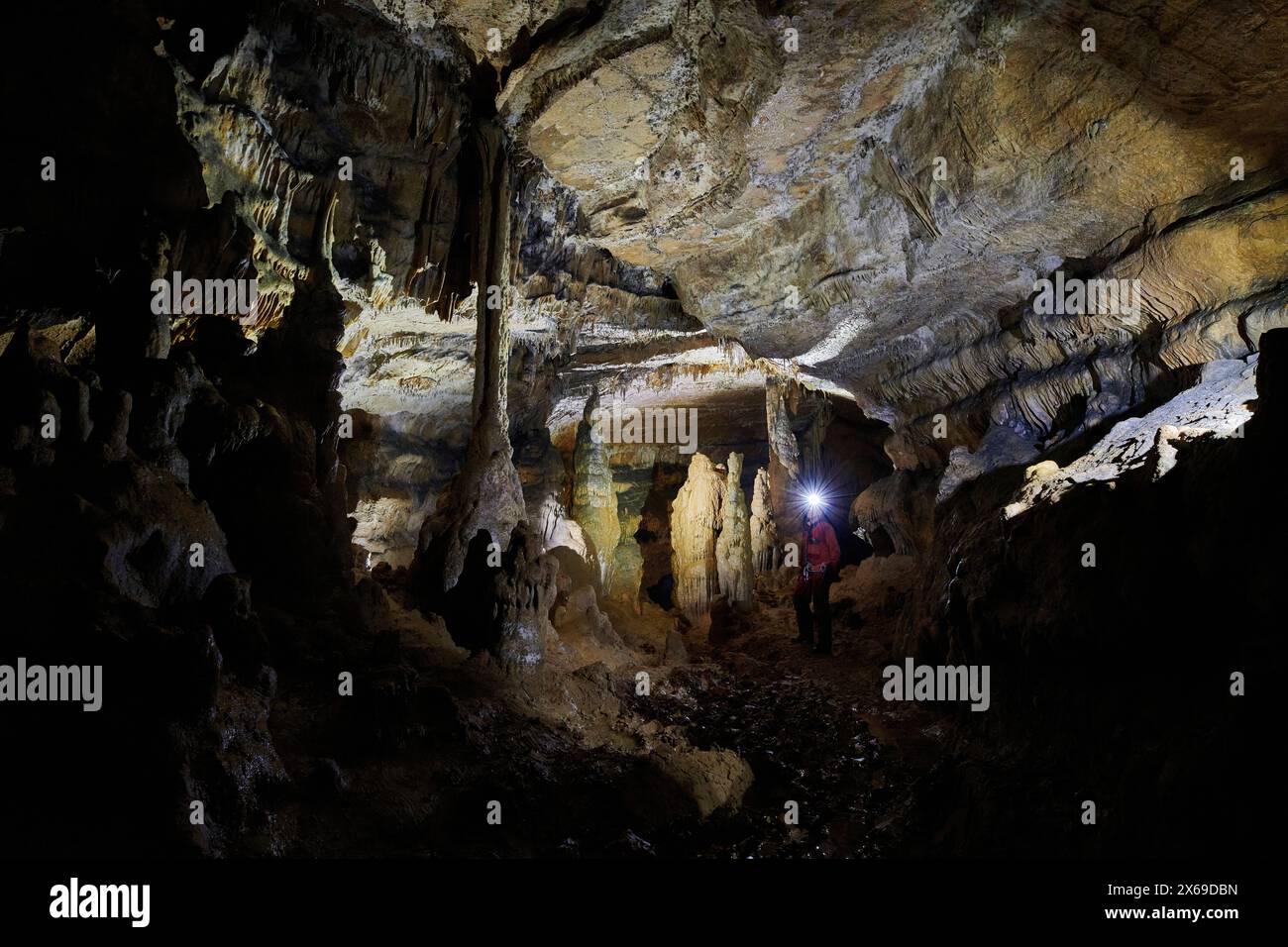 Speleologist in a cave, column, stalagmites and stalactites, stone forest Stock Photo