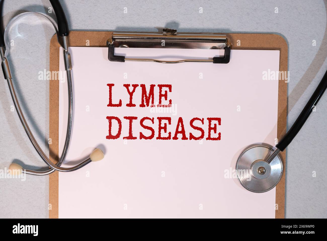 A notepad with the diagnosis Lyme Disease, a stethoscope and a black pencil on yellow surface Stock Photo