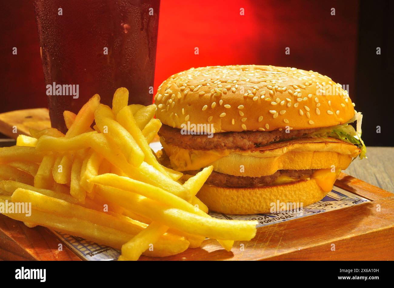Hamburger with chips and coca cola drink over red gradient Stock Photo