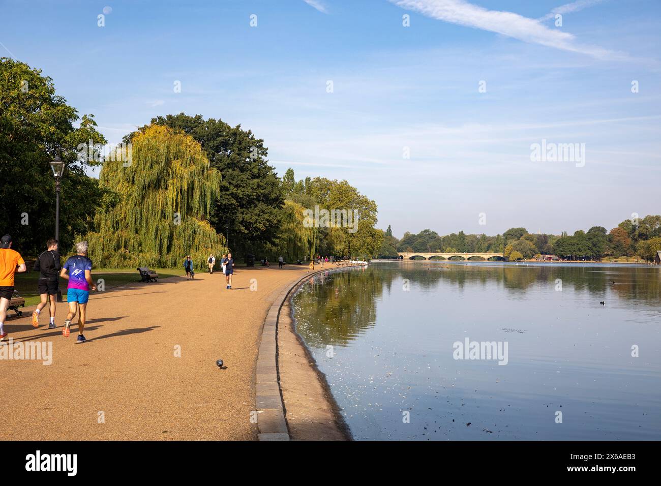 Hyde Park London, men running jogging along the Serpentine shore, early ...