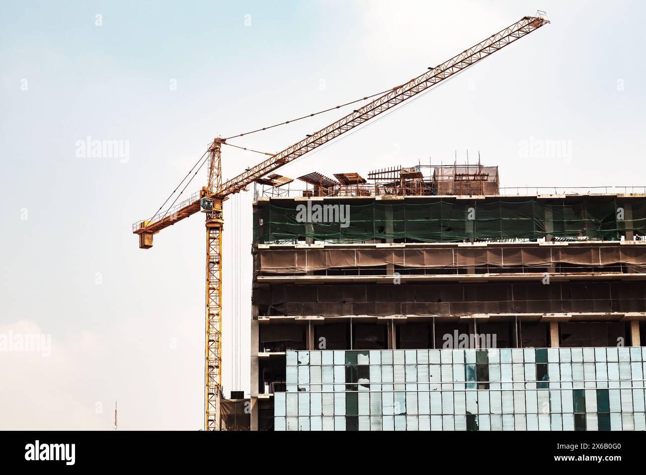 about the tower crane at the construction site and blue sky by emphasizing the tower crane Stock Photo