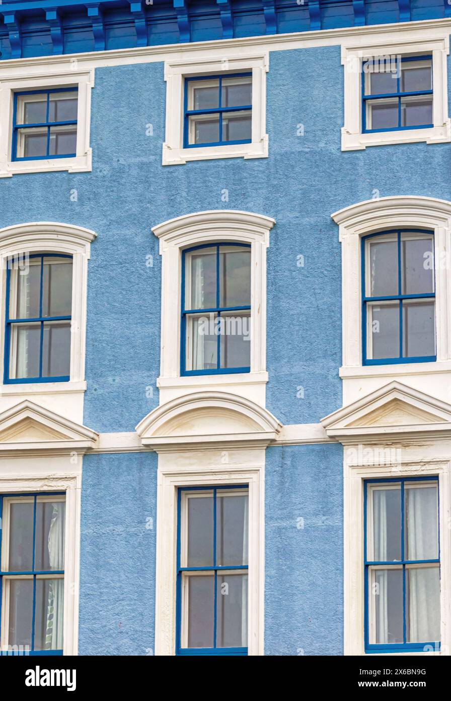 Coloured multi-storey boarding house set in a seaside town. The ...
