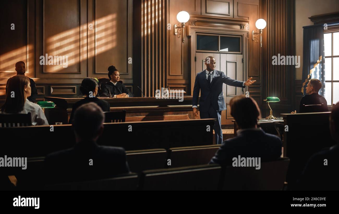 Court of Law Trial in Session: Portrait of Charismatic Male Public Defender Making Touching, Passionate Speech to Judge and Jury. Attorney Lawyer Protecting Client, Presenting Case. Stock Photo