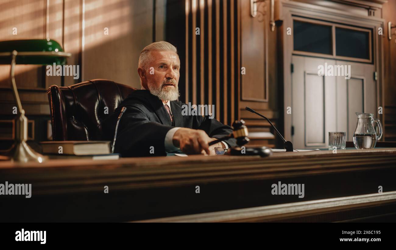 Court of Law Trial: Portrait of Impartial Judge Reading Decision, striking Gavel. Justice Pronouncing Sentence. Judgment after Deliberation. Guilty, Not Guilty Verdict. Cinematic Concept Rule of Law Stock Photo