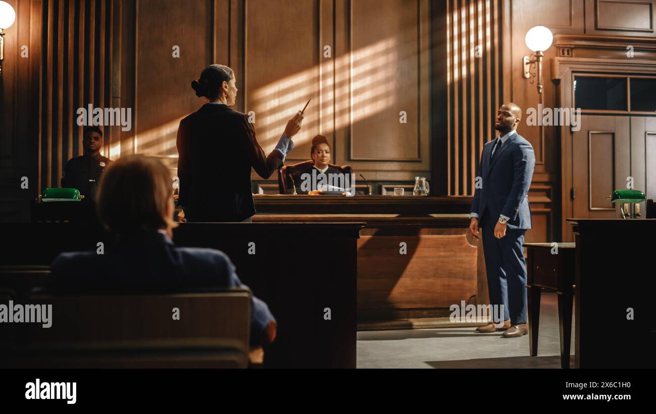 Court of Law Trial in Session: Charismatic Male Public Defender Making Touching, Passionate Speech to Judge and Jury. Female Prosecutor Objecting to His Arguments and Delivering Her Accusations. Stock Photo