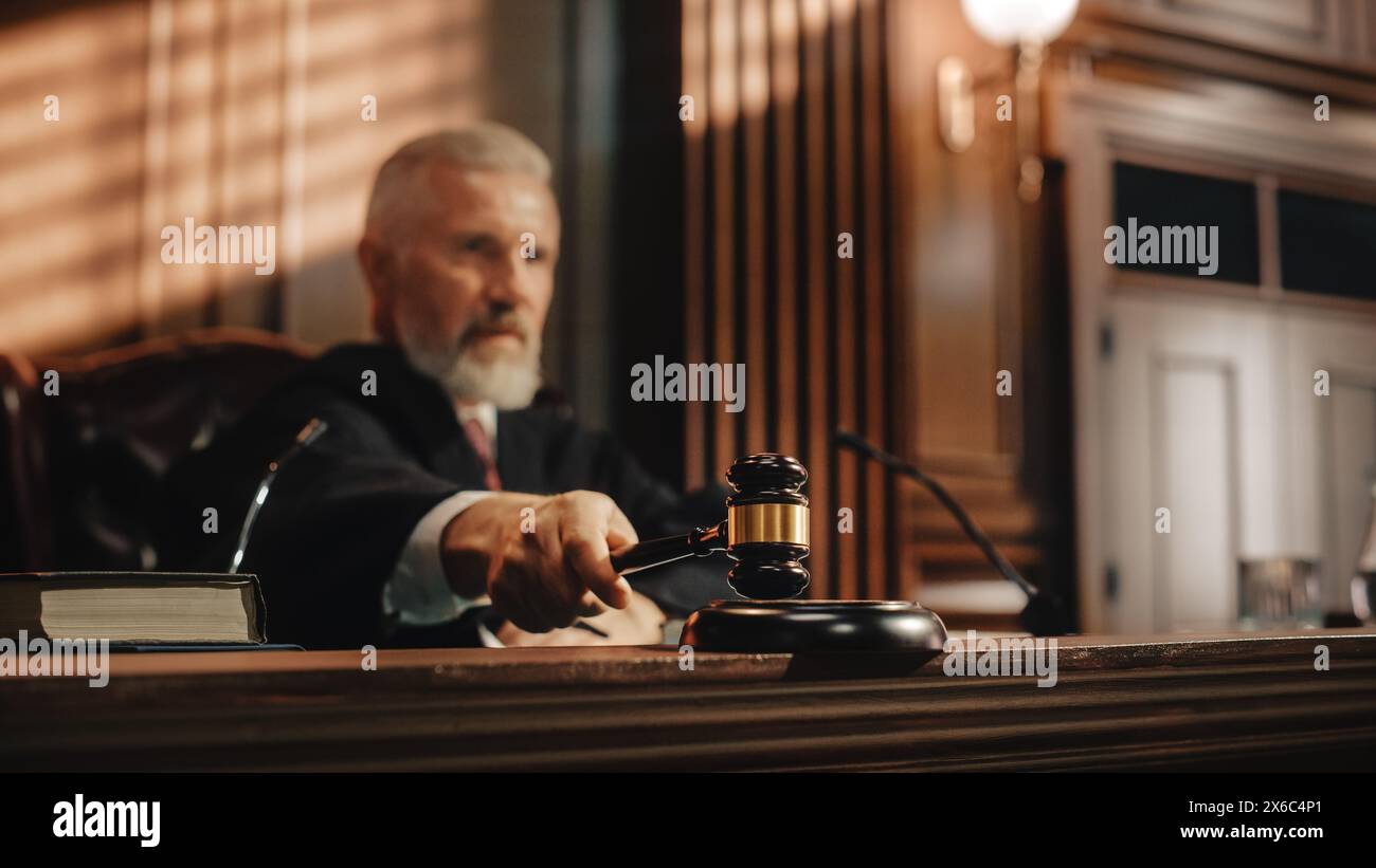Court of Law and Justice Trial Session: Imparcial Honorable Judge Pronouncing Sentence, striking Gavel. Focus on Mallet, Hammer. Cinematic Shot of Dramatic Not Guilty Verdict. Stock Photo