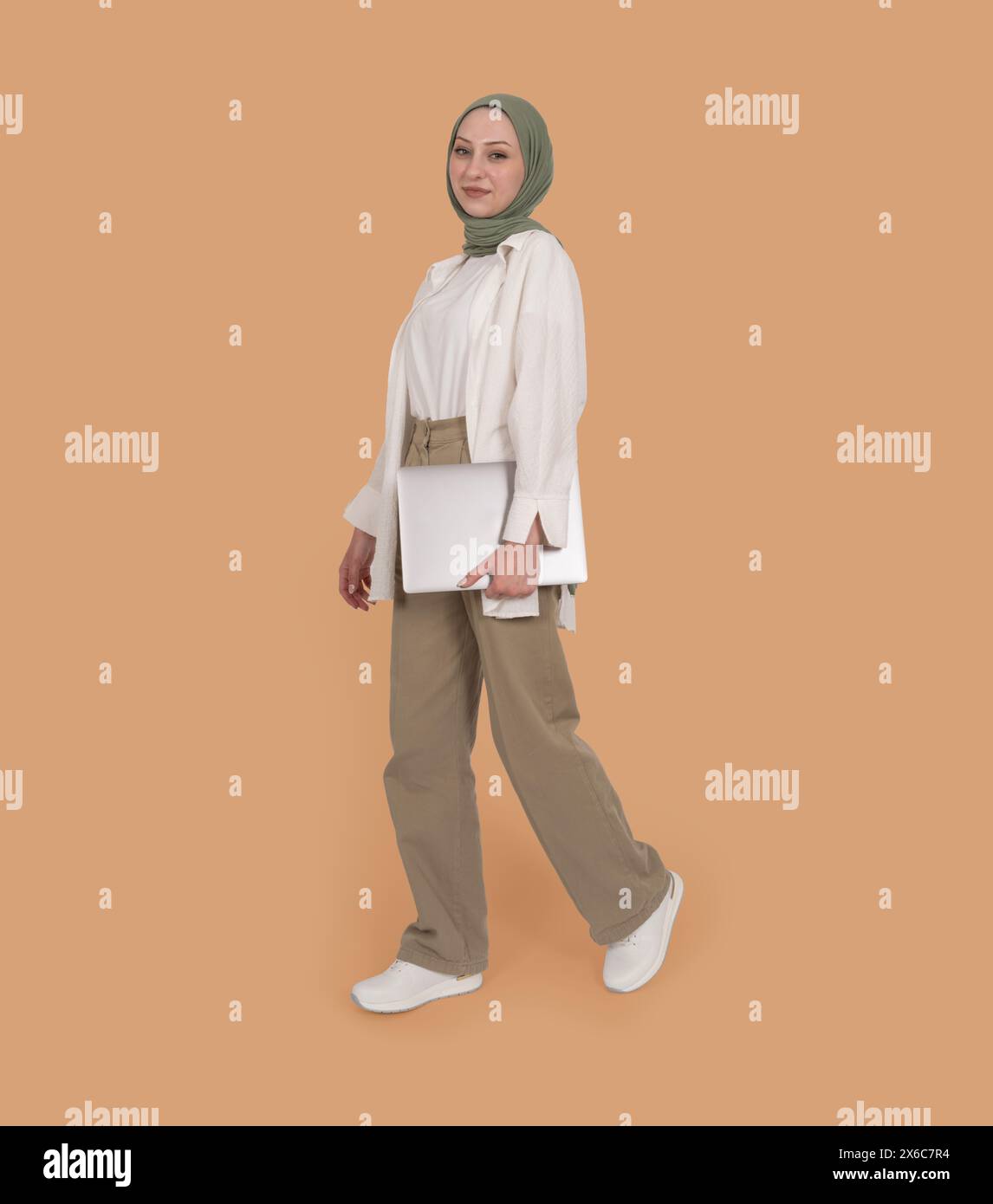 Full length view young caucasian woman in abaya hijab holding closed ...