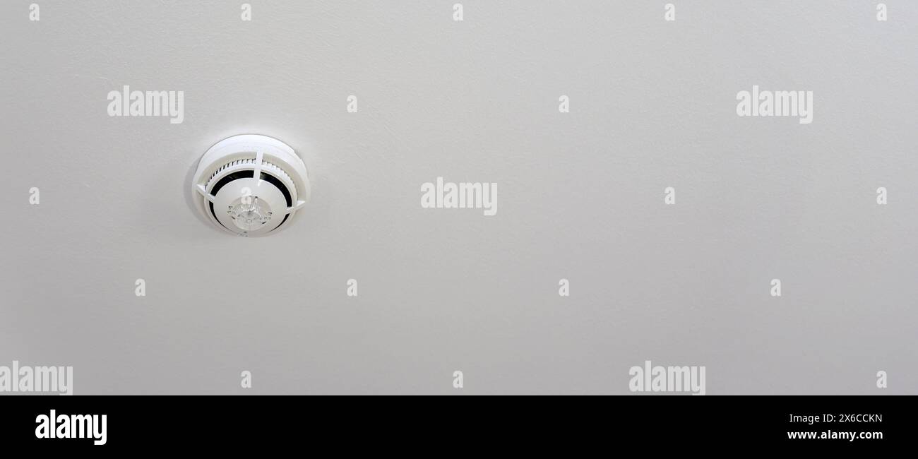 White ceiling mounted fire safety device smoke detector Stock Photo