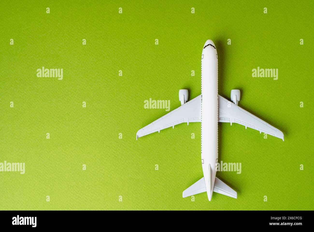 Passenger plane on a green background and space for text. Environmentally friendly fuel. Technological innovations in aviation industry. Green air tra Stock Photo