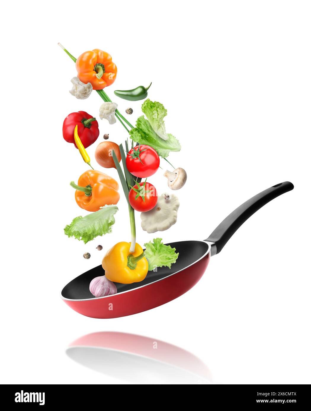 Frying pan and different vegetables in air on white background Stock Photo
