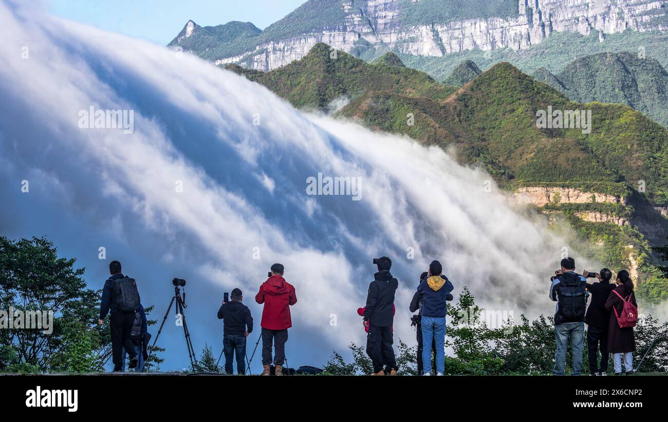 Chongqing. 13th May, 2024. Tourists enjoy the scene of clouds streaming ...