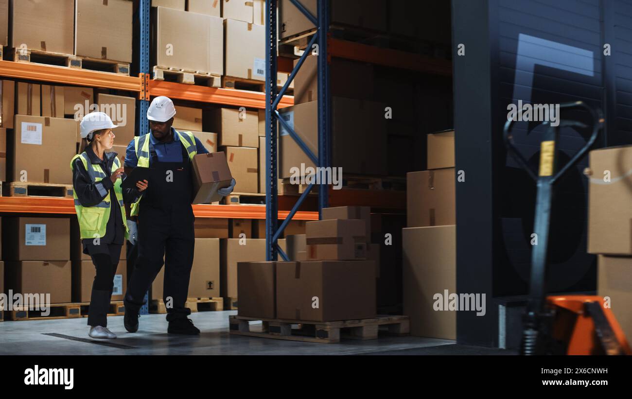 Outside of Logistics Distributions Warehouse: Inventory Manager Using Tablet Computer, talking to Worker with Cardboard Box Walking out of Warehouse. Online Orders, E-Commerce. Stock Photo