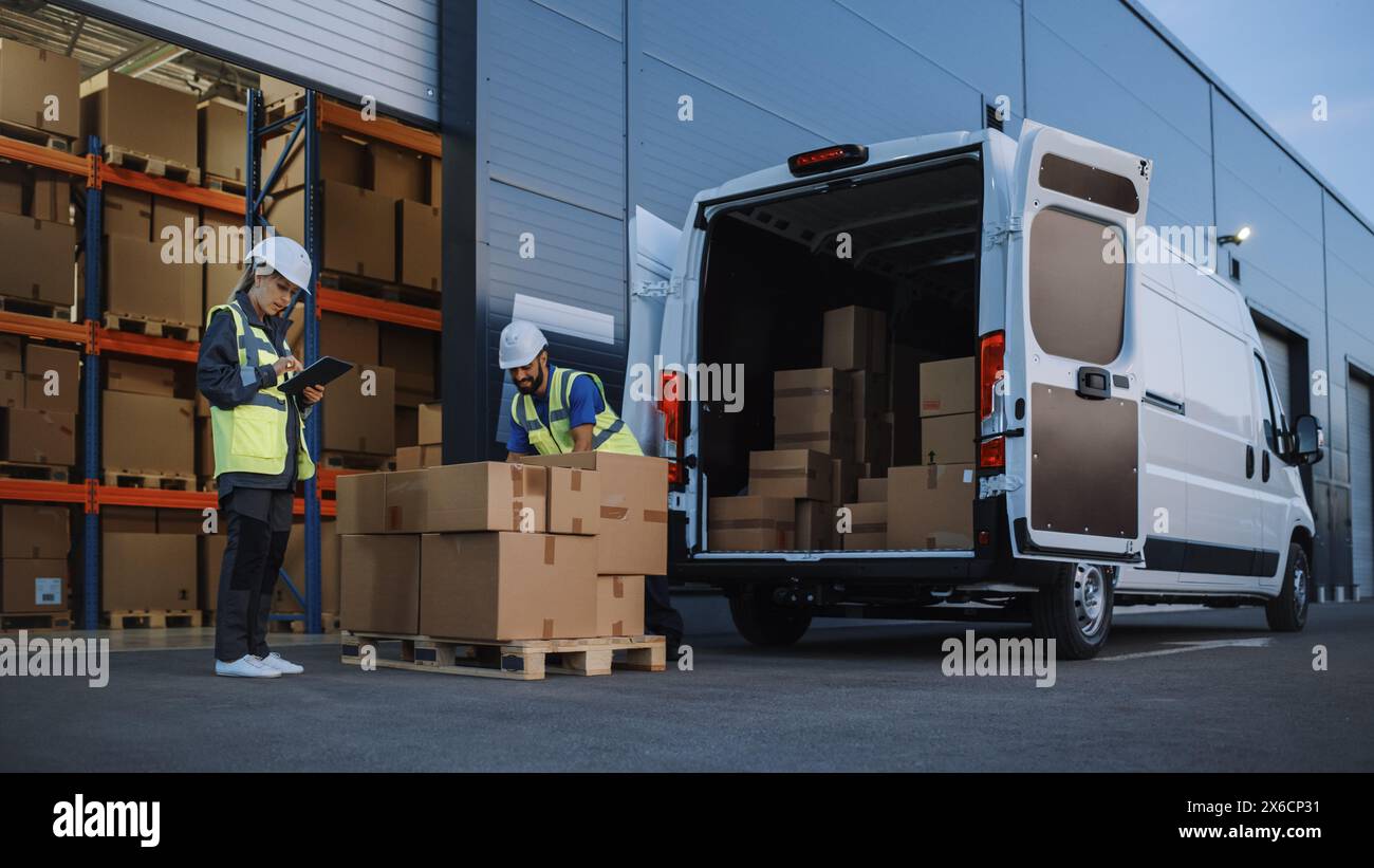 Outside of Logistics Distributions Warehouse With Inventory Manager Using Tablet Computer, talking to Worker Loading Delivery Truck with Cardboard Boxes. Online Orders, Purchases, E-Commerce Goods Stock Photo
