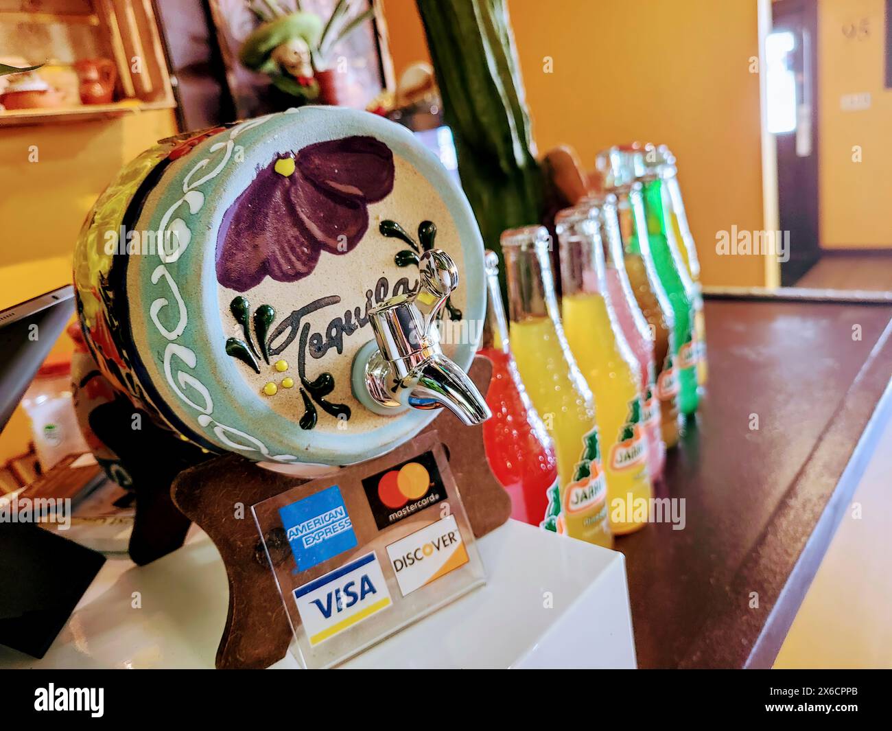 Hand-Painted Tequila Dispenser and Payment Stand in Cozy Cafe, Low Angle View Stock Photo