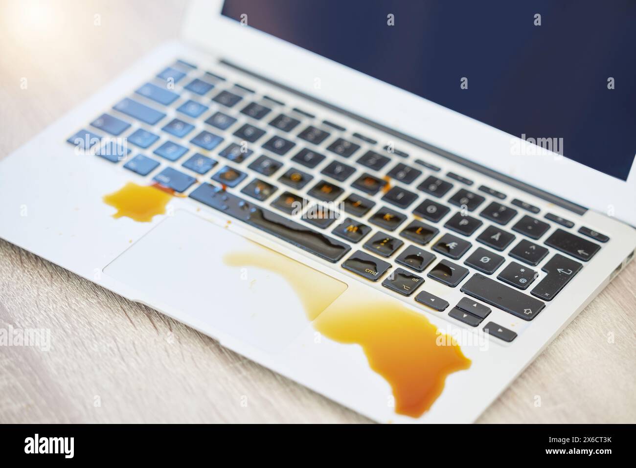 Accident, coffee spill or mistake and laptop with damage on desk or