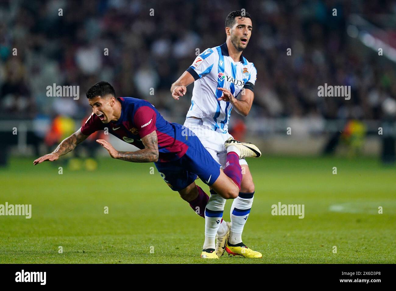 Barcelona, Spain. 13th May, 2024. Joao Cancelo of FC Barcelona and Mikel Merino of Real Sociedad during the La Liga EA Sports match between FC Barcelona and Real Sociedad played at Lluis Companys Stadium on May 13, 2024 in Barcelona, Spain. (Photo by Sergio Ruiz/PRESSINPHOTO) Credit: PRESSINPHOTO SPORTS AGENCY/Alamy Live News Stock Photo