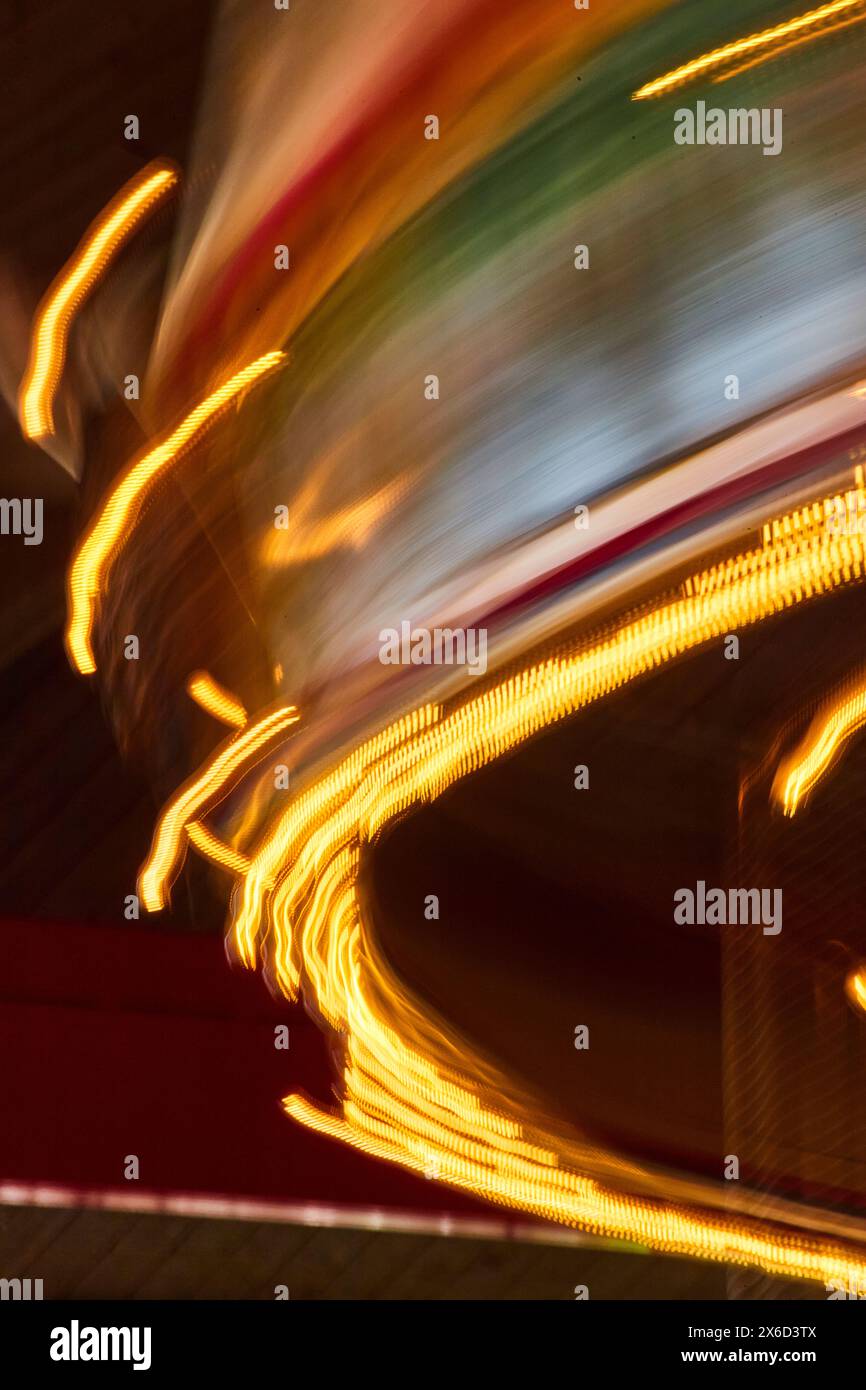 Abstract Light Streaks from Carousel at Night, Side View Motion Blur Stock Photo