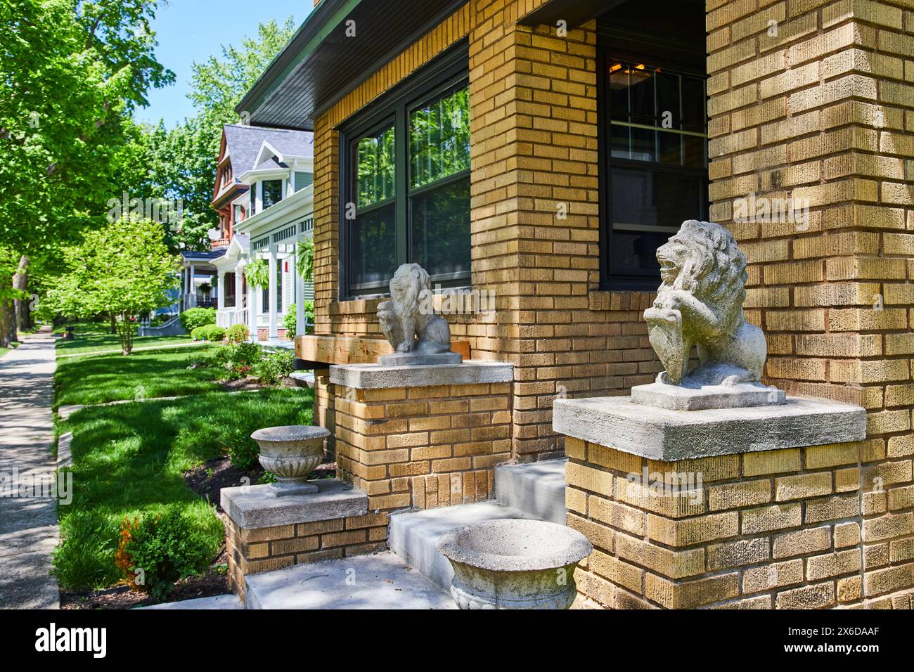 Sunlit Suburban Street with Brick House and Lion Statues, Fort Wayne