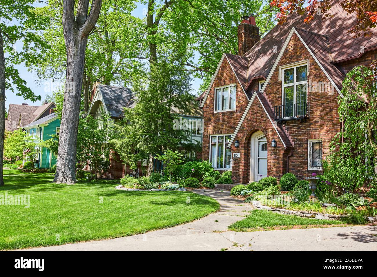 Charming Suburban Homes with Lush Gardens in Bright Daylight Stock Photo