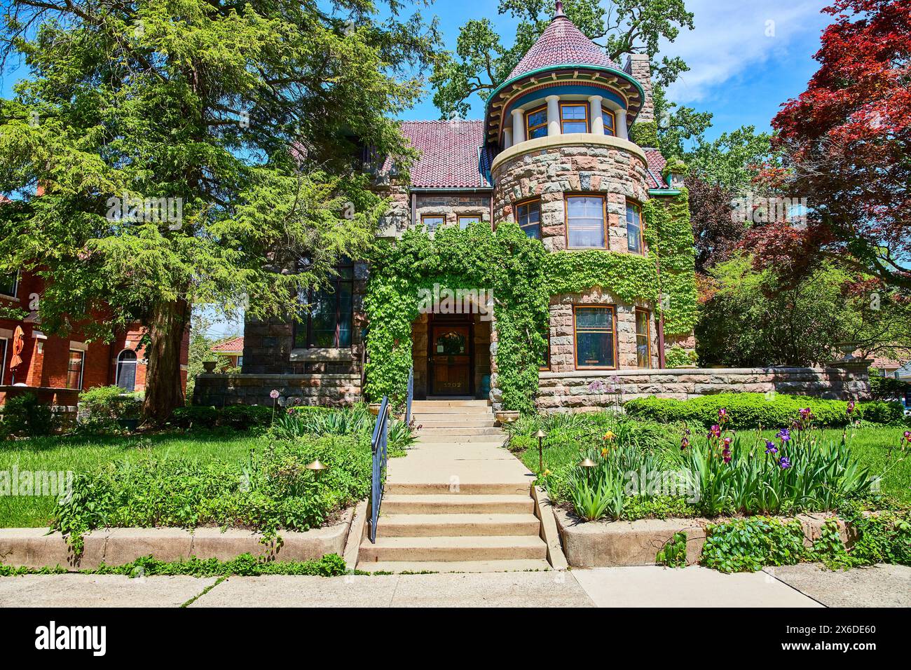 Historic Ivy-Covered Stone House with Lush Garden, Fort Wayne Stock Photo