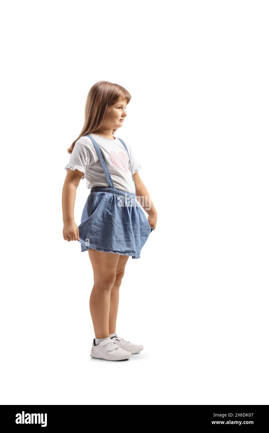 Profile shot of a little girl holding her skirt isolated on white ...