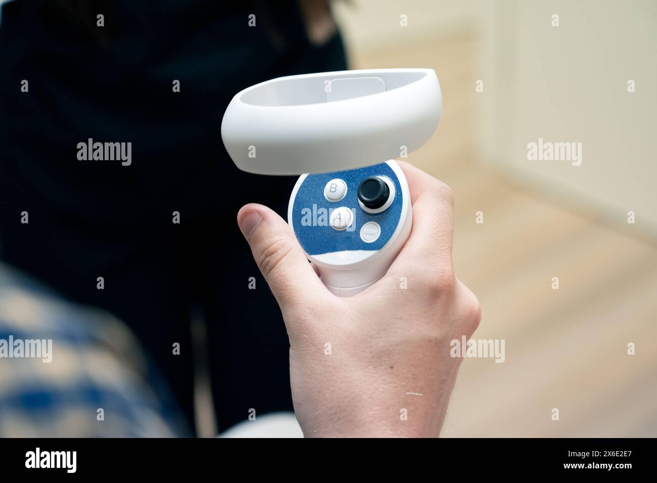 Patients' thumb and hand control the virtual joystick for examination in modern eye doctor office. Stock Photo