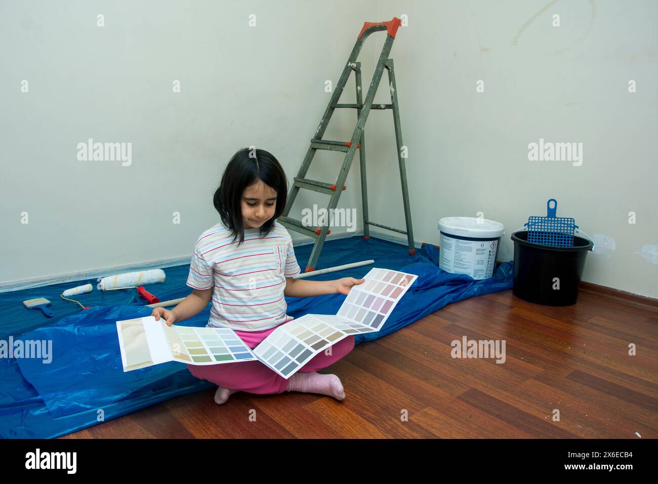 Little girl chooses her room's wall color from the catalog Stock Photo ...