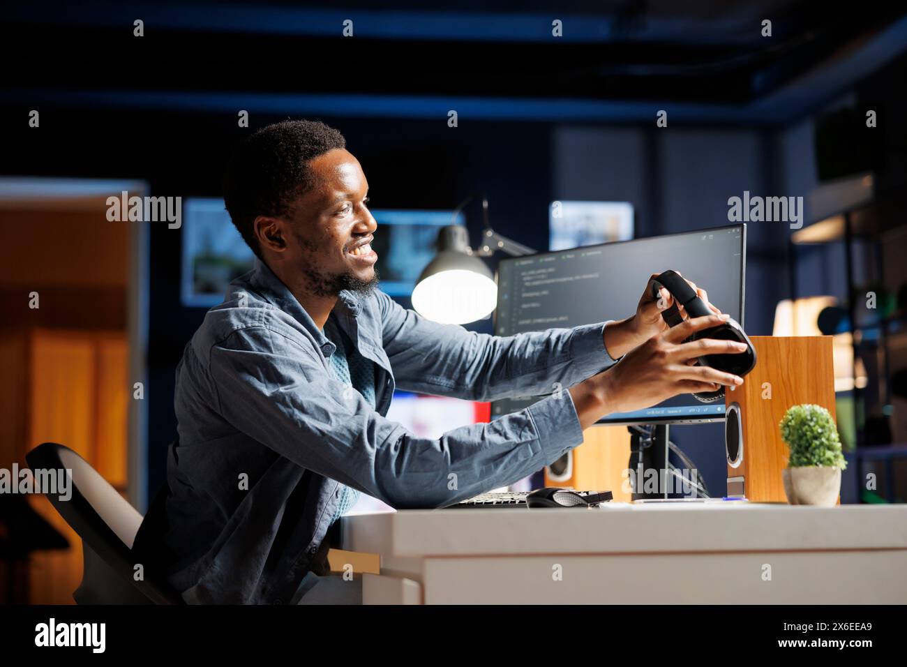 IT specialist coding html script and listens to music on headset, working as a system engineer to create technical support protection. Programmer working from home on terminal window. Stock Photo