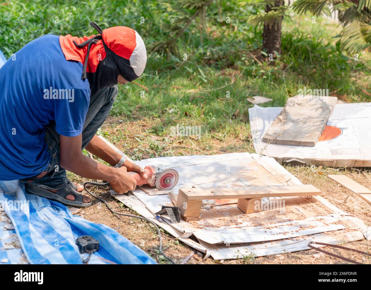 Worker cutting a tile with a grinder at construction site Stock Photo ...