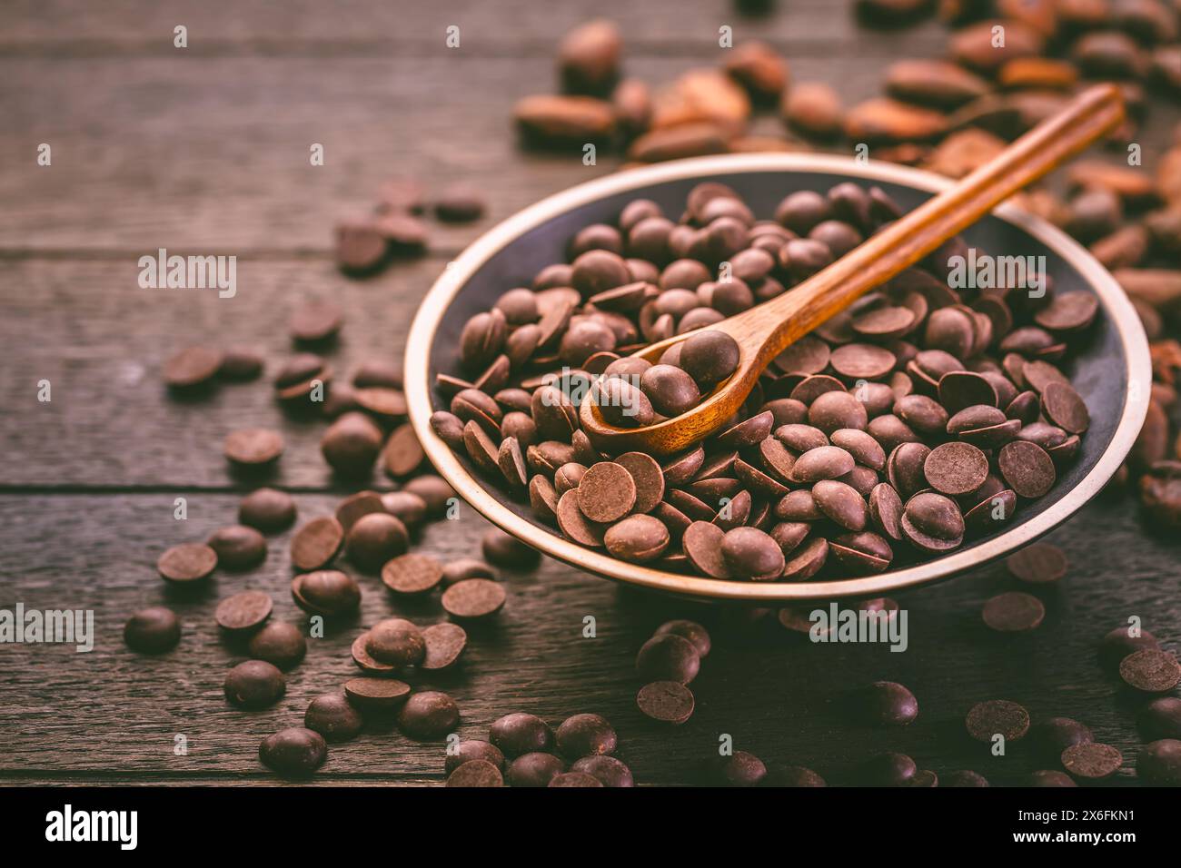 Bittersweet dark chocolate drops with cocoa beans, sugar-free couverture, baking and cooking ingredient Stock Photo