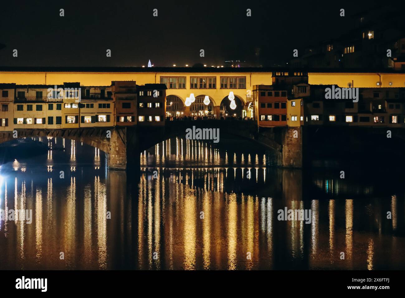 The Ponte Vecchio at night, a medieval stone closed-spandrel segmental ...