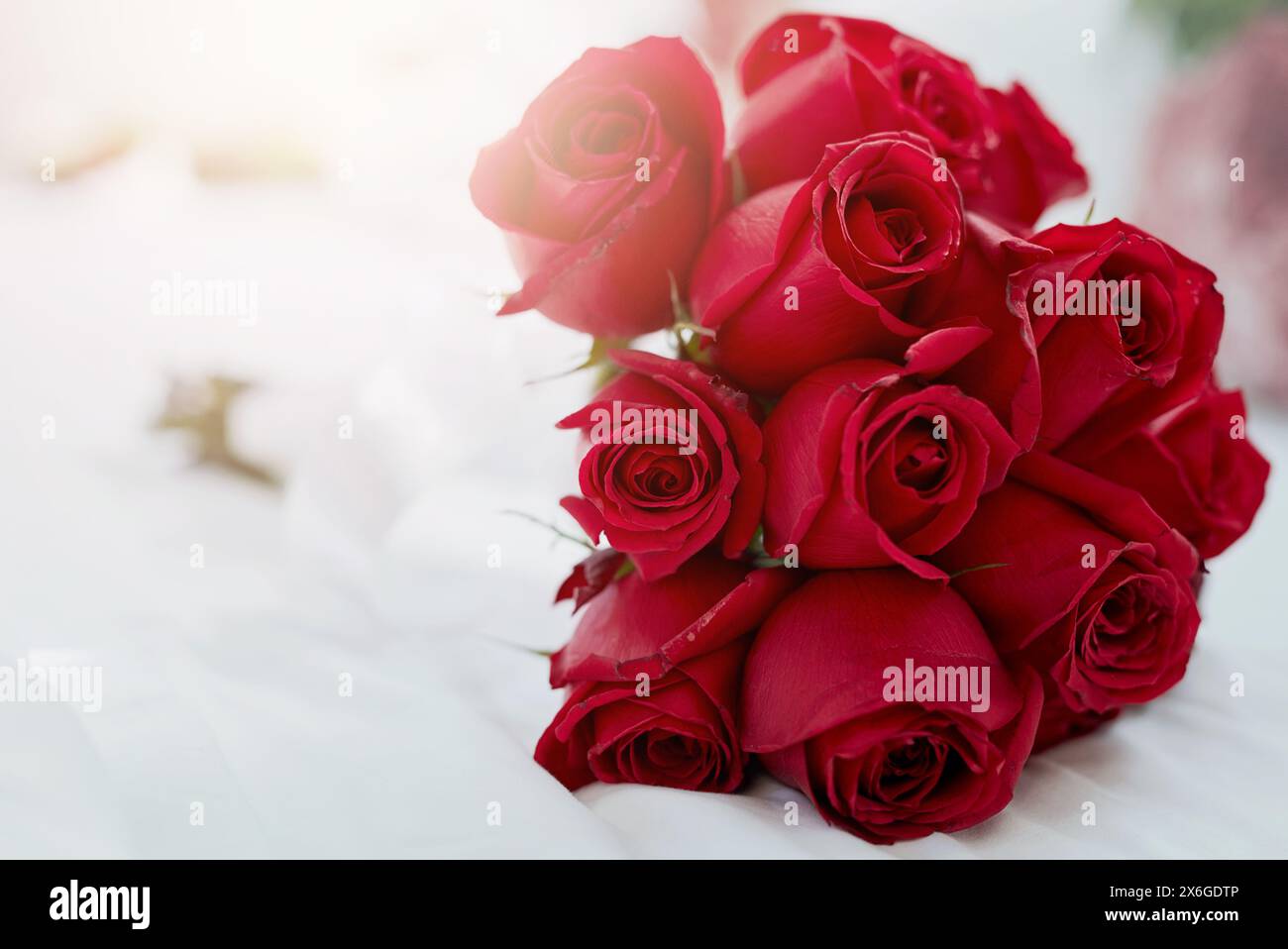 Home, bedroom and bunch of red roses, sunshine and lens flare with ...
