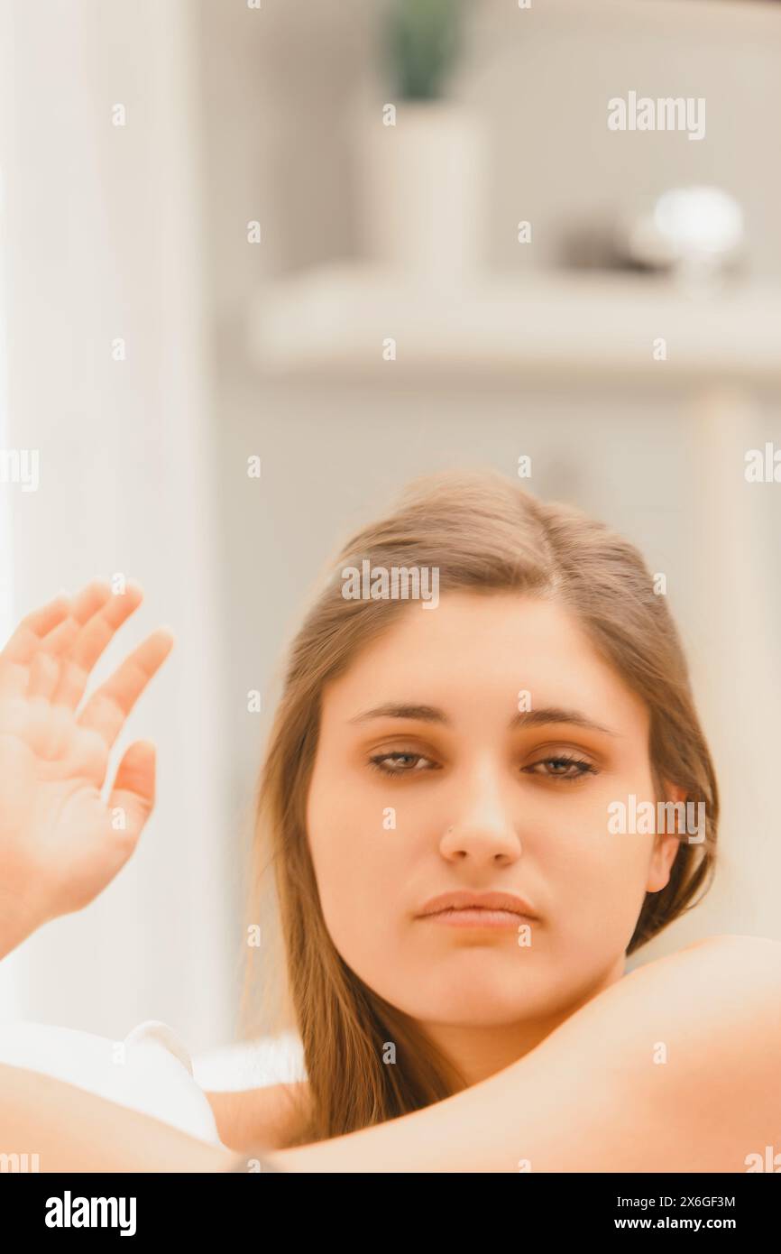 Captured in a moment of sarcasm, the young woman's aloof expression and casual gesture speak volumes Stock Photo
