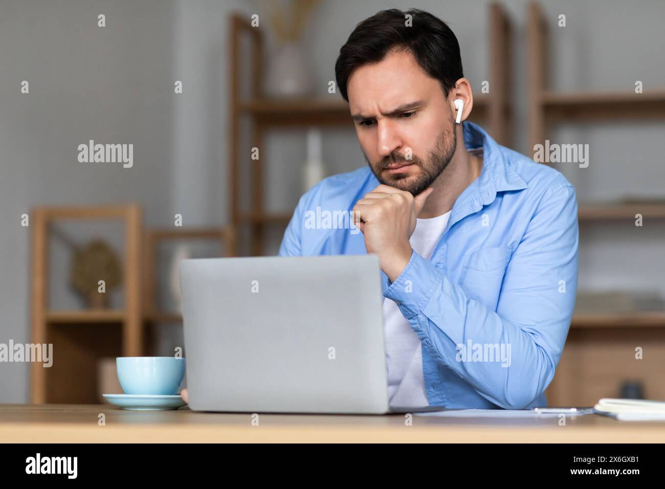 Focused Man Using Laptop for Work During Daytime in Office Stock Photo
