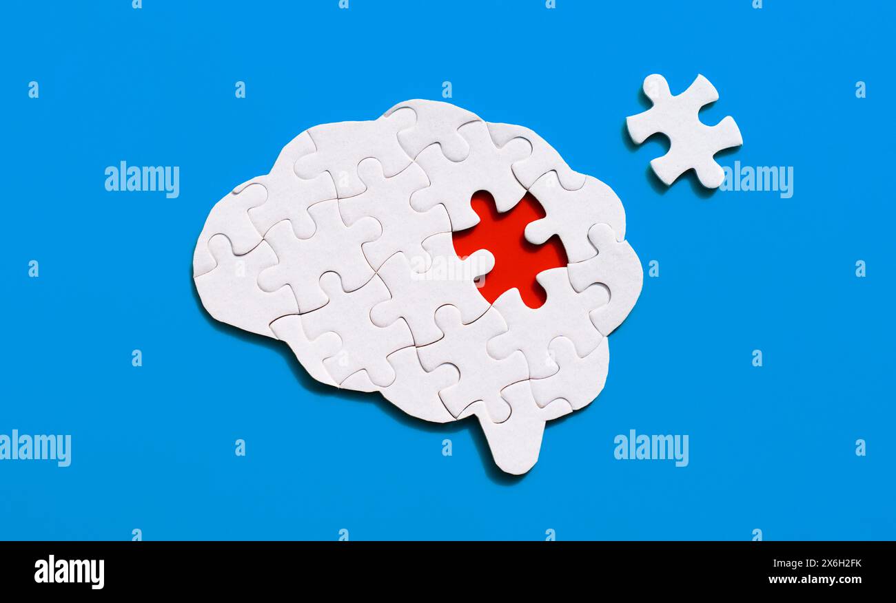 Brain-shaped puzzle with the missing piece, set against a gentle blue background. Intellect, curiosity and mental exploration concept. Stock Photo