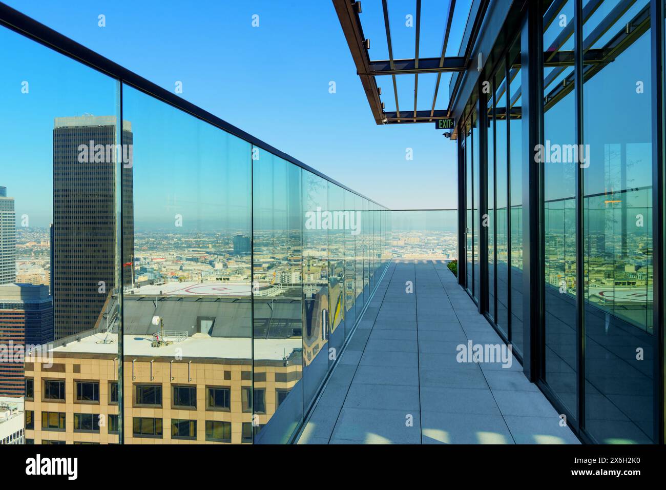 Spacious balcony in Los Angeles residential complex boasting a sleek glass facade and stunning views of downtown Los Angeles. Stock Photo