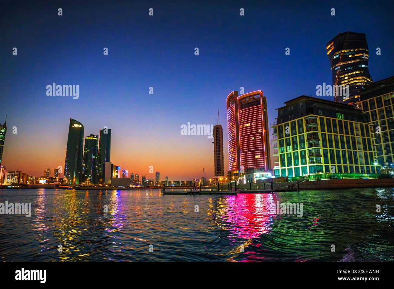 Night view of modern resorts reflecting in water in Bahrain Stock Photo