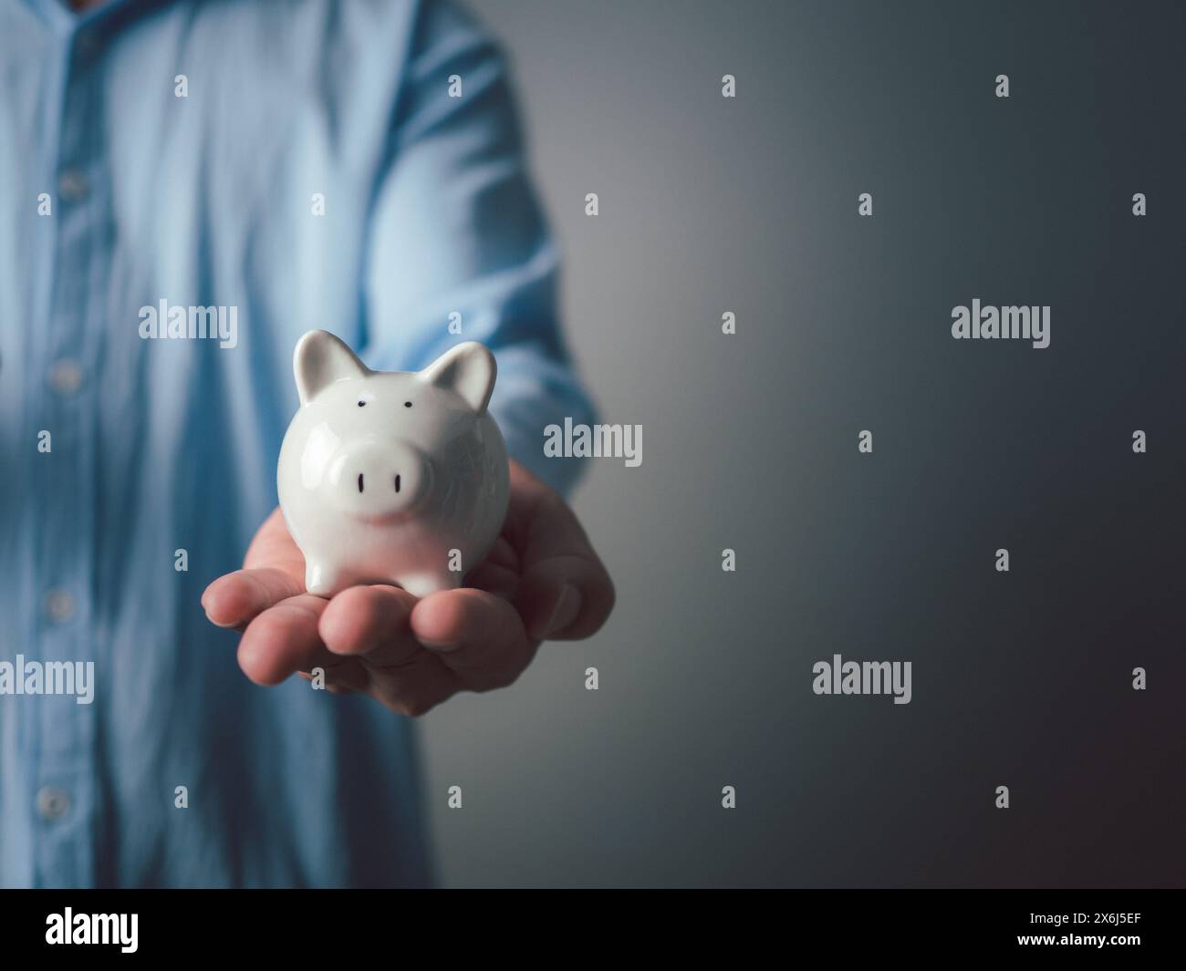 Money saving concept. Businessman holding the white piggy bank for saving money concept. Save for investment, banking, loan, home loan, Financial plan Stock Photo