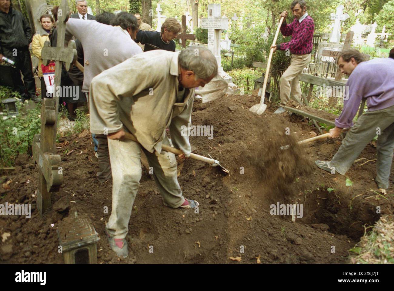 Bucharest, Romania, approx. 1992. Workers in a cemetery shoveling dirt