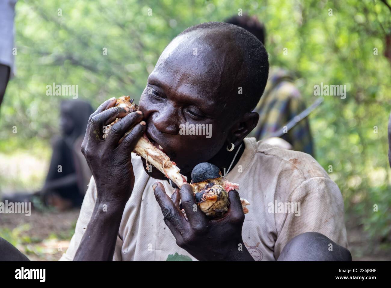 Members of the Mursi tribe in Ethiopia eat freshly hunted bush meat ...