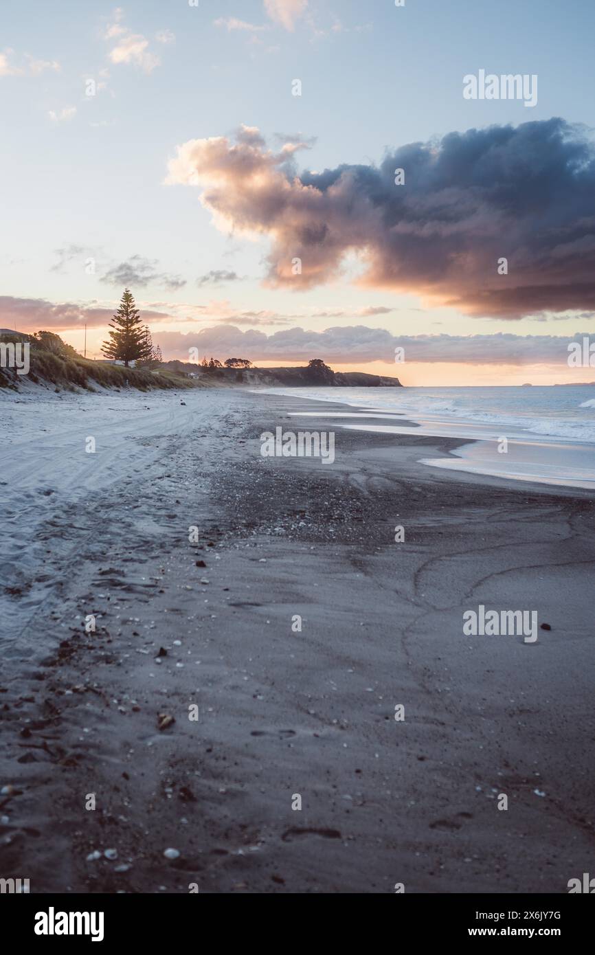 Deserted beach at sunset with dramatic clouds in the sky Stock Photo