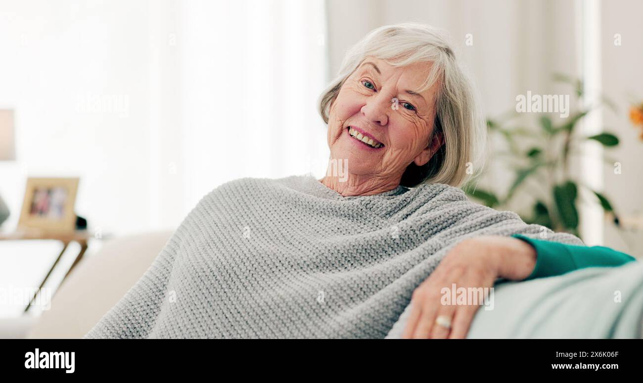 Face, funny and senior woman on couch, home and happiness with retirement, relax and cheerful. Portrait, elderly lady and female person on a sofa Stock Photo